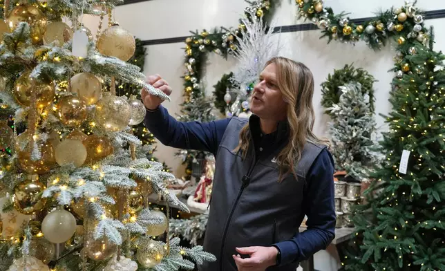 Mac Harman, founder and CEO of Balsam Hill, looks at artificial Christmas trees at the company's outlet store in Burlingame, Calif. on Dec. 10, 2025. (AP Photo/Terry Chea)