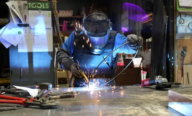 Juan Gonzalez assembles an artificial Christmas wreath at Lee Display's warehouse, in Fairfield, Calif., Tuesday, Dec. 9, 2025. (AP Photo/Terry Chea)