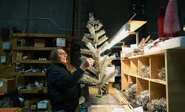 Melissa Webb assembles an artificial Christmas tree at Lee Display's warehouse, in Fairfield, Calif., Tuesday, Dec. 9, 2025. (AP Photo/Terry Chea)