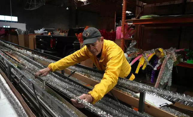 Mark Latino, CEO of Lee Display, works with a machine that makes tinsel brush for artificial Christmas trees at the company's warehouse, in Fairfield, Calif., Tuesday, Dec. 9, 2025. (AP Photo/Terry Chea)