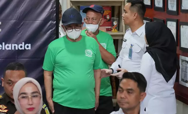 Dutch nationals facing death row Siegfried Mets, rear, and serving life in prison, Ali Tokman, left, attend the handover ceremony between the representatives of Indonesian and Dutch government before their repatriation to the Netherlands, at Cipinang Prison in Jakarta, Indonesia, Monday, Dec. 8, 2025. (AP Photo/Tatan Syuflana)