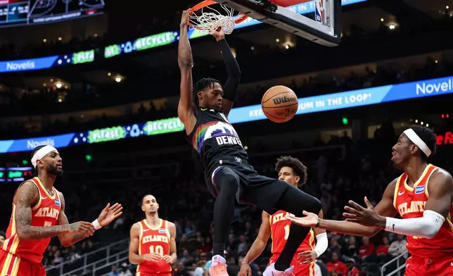 Denver Nuggets guard Peyton Watson, center, dunks during the first half of an NBA basketball game against the Atlanta Hawks, Friday, Dec. 5, 2025, in Atlanta. (AP Photo/Colin Hubbard)