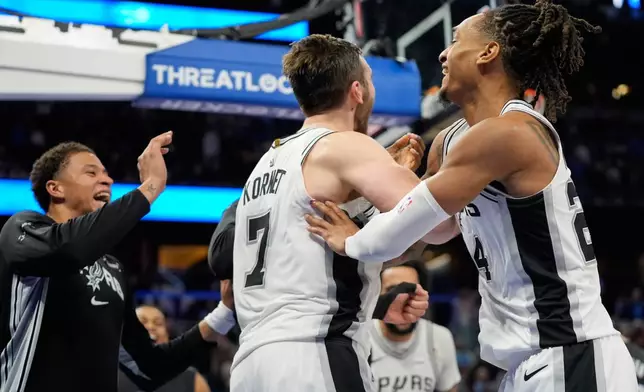 San Antonio Spurs center Luke Kornet (7) celebrates with teammates after blocking a shot by Orlando Magic forward Franz Wagner to win an NBA basketball game, Wednesday, Dec. 3, 2025, in Orlando, Fla. (AP Photo/John Raoux)