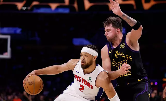 Detroit Pistons guard Cade Cunningham (2) looks to pass the ball while being guarded by Los Angeles Lakers guard Luka Doncic (77) during the first half of an NBA basketball game Tuesday, Dec. 30, 2025, in Los Angeles. (AP Photo/Caroline Brehman)