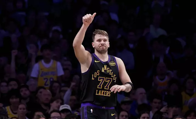 Los Angeles Lakers guard Luka Doncic (77) reacts after scoring during the first half of an NBA basketball game against the Detroit Pistons, Tuesday, Dec. 30, 2025, in Los Angeles. (AP Photo/Caroline Brehman)