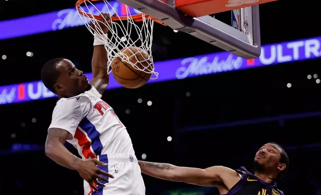 Detroit Pistons guard Javonte Green (31) dunks the ball while being guarded by Los Angeles Lakers guard Nick Smith Jr. (20) during the first half of an NBA basketball game Tuesday, Dec. 30, 2025, in Los Angeles. (AP Photo/Caroline Brehman)
