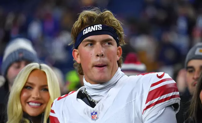 New York Giants quarterback Jaxson Dart, center, looks on before an NFL football game against the New England Patriots, Monday, Dec. 1, 2025, in Foxborough, Mass. (AP Photo/Steven Senne)