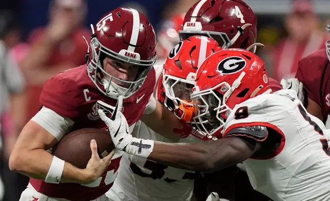 Alabama quarterback Ty Simpson (15) is tackles by Georgia linebacker Chris Cole (9) during the second half of a Southeastern Conference championship NCAA college football game, Saturday, Dec. 6, 2025, in Atlanta. (AP Photo/Mike Stewart)