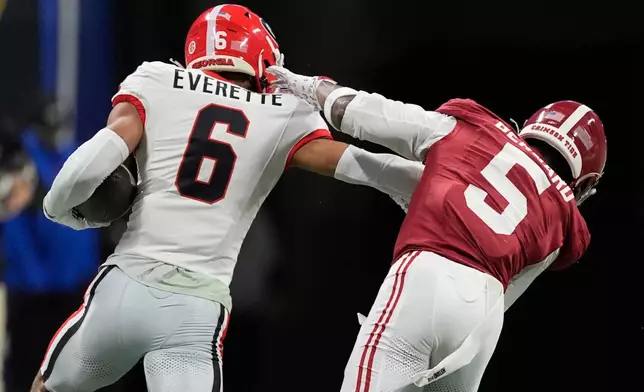 Georgia defensive back Daylen Everette (6) runs an intercepted ball against Alabama wide receiver Germie Bernard (5) during the first half of a Southeastern Conference championship NCAA college football game, Saturday, Dec. 6, 2025, in Atlanta. (AP Photo/Mike Stewart)