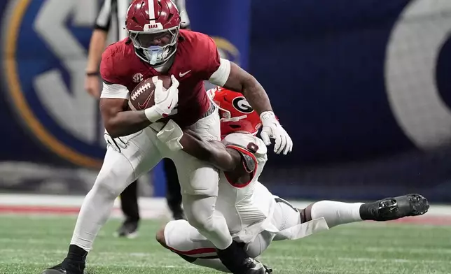 Alabama running back Daniel Hill (4) runs against Georgia linebacker Chris Cole (9) during the first half of a Southeastern Conference championship NCAA college football game, Saturday, Dec. 6, 2025, in Atlanta. (AP Photo/Mike Stewart)