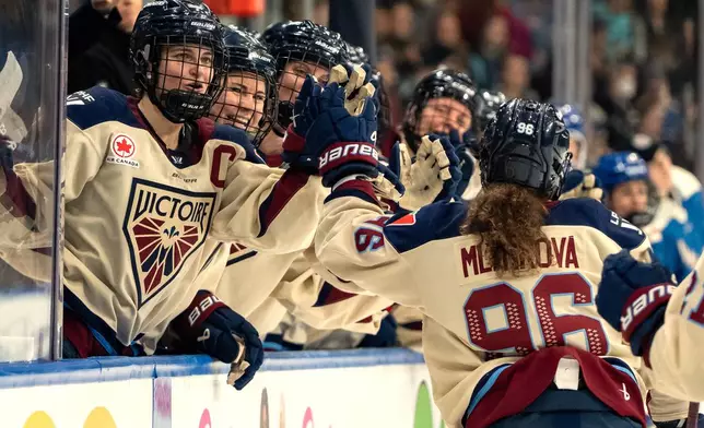Montreal Victoire's Marie-Philip Poulin (29) celebrates with Natalie Mlynkova (96) after Mlýnková's goal against the Vancouver Goldeneyes during the second period of a PWHL hockey game in Vancouver, British Columbia, Saturday, Dec. 20, 2025. (Ethan Cairns/The Canadian Press via AP)