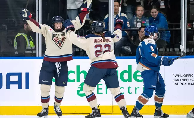 Montreal Victoire's Shiann Darkangelo celebrates her goal against the Vancouver Goldeneyes with Jessica Digirolamo (22) as Vancouver Goldeneyes' Izzy Daniel (8) skates away during the third period of a PWHL hockey game in Vancouver, British Columbia, Saturday, Dec. 20, 2025. (Ethan Cairns/The Canadian Press via AP)