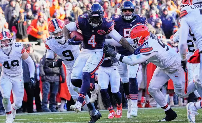 Chicago Bears running back D'Andre Swift (4) carries for a touchdown between Cleveland Browns safety Grant Delpit (9) and defensive end Alex Wright (91) in the second half of an NFL football game in Chicago, Sunday, Dec. 14, 2025. (AP Photo/Nam Y. Huh)