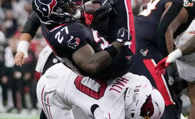 Houston Texans running back Woody Marks (27) scores a touchdown as Arizona Cardinals cornerback Darren Hall arrives late for the tackle during the first half of an NFL football game Sunday, Dec. 14, 2025, in Houston. (AP Photo/Ashley Landis)