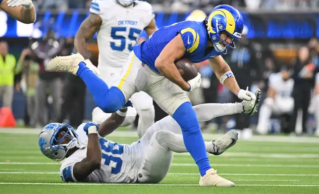 Los Angeles Rams wide receiver Puka Nacua (12) runs over Detroit Lions safety Erick Hallett (36) after a catch during the second half of an NFL football game against the Detroit Lions, Sunday, Dec. 14, 2025, in Inglewood, Calif. (AP Photo/Katie Chin)