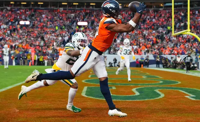 Denver Broncos' Courtland Sutton catches a touchdown pass in front of Green Bay Packers' Keisean Nixon during the second half of an NFL football game Sunday, Dec. 14, 2025, in Denver. (AP Photo/Jack Dempsey)