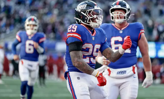 New York Giants running back Tyrone Tracy Jr. (29) reacts after scoring a touchdown against the Washington Commanders during the third quarter of an NFL football game, Sunday, Dec. 14, 2025, in East Rutherford, N.J. (AP Photo/Adam Hunger)
