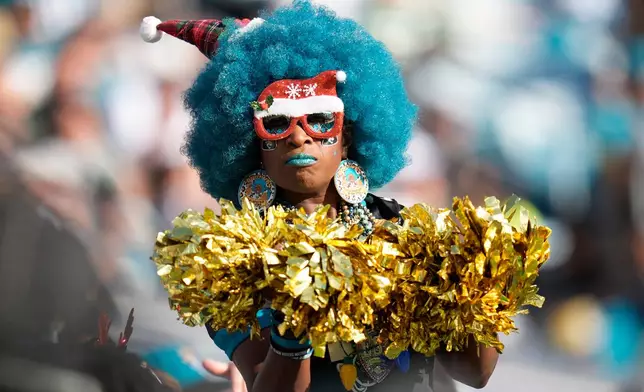 A Jacksonville Jaguars fan cheers during the second half of an NFL football game against the New York Jets, Sunday, Dec. 14, 2025, in Jacksonville, Fla. (AP Photo/John Raoux)
