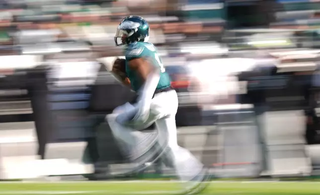 Philadelphia Eagles quarterback Jalen Hurts (1) runs with the ball during the first half of an NFL football game against the Las Vegas Raiders on Sunday, Dec. 14, 2025, in Philadelphia. (AP Photo/Matt Slocum)
