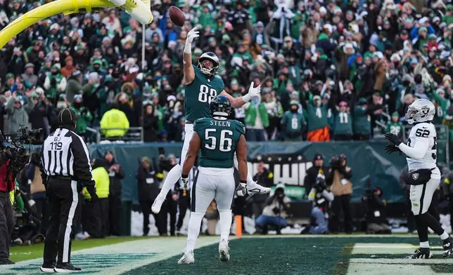 Philadelphia Eagles tight end Dallas Goedert (88) celebrates scoring a touchdown with Eagles offensive tackle Tyler Steen during the first half of an NFL football game against the Las Vegas Raiders on Sunday, Dec. 14, 2025, in Philadelphia. (AP Photo/Matt Rourke)