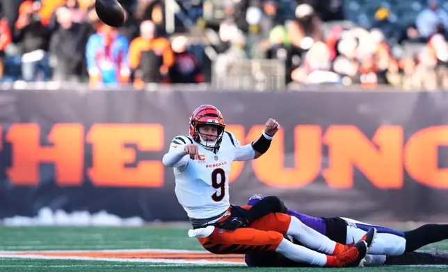 Cincinnati Bengals quarterback Joe Burrow (9) throws as he is tackled by Baltimore Ravens linebacker Kyle van Noy during the second half of an NFL football game, Sunday, Dec. 14, 2025, in Cincinnati. (AP Photo/Jeff Dean)