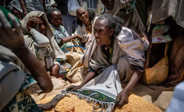FILE - An Ethiopian woman argues with others over the allocation of yellow split peas after it was distributed by the Relief Society of Tigray in the town of Agula, in the Tigray region of northern Ethiopia, May 8, 2021. (AP Photo/Ben Curtis, File)