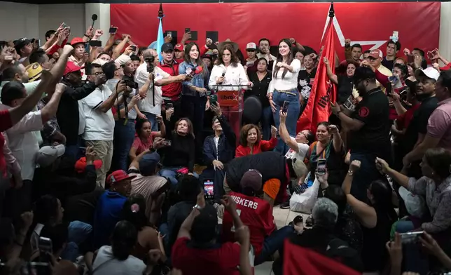 Supporters of the ruling party LIBRE, Liberty and Refoundation, cheer their presidential candidate Rixi Moncada, center top, at the party's headquarters in Tegucigalpa, Honduras, Sunday, Dec. 7, 2025. (AP Photo/Moises Castillo)