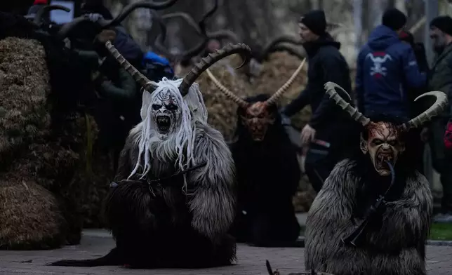 Participants wearing traditional Krampus and Perchten costumes perform during a Krampus run in Itter, Austria, Friday, Dec. 5, 2025. (AP Photo/Matthias Schrader)