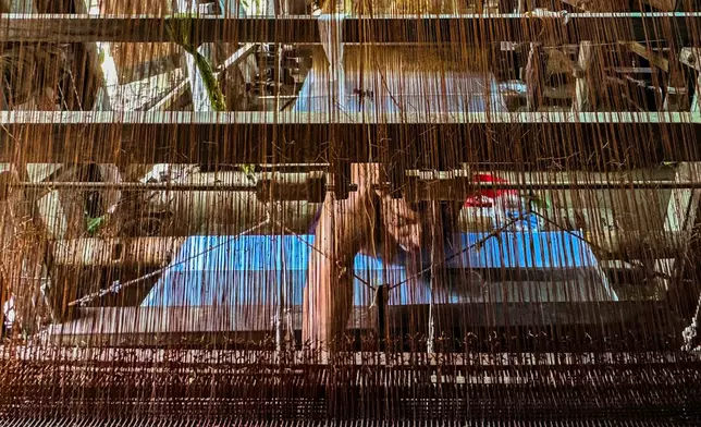 A weaver crafts a Tangail saree on a traditional hand-operated loom at a weaving workshop in Tangail District, Bangladesh, Nov. 5, 2025. (AP Photo/Mahmud Hossain Opu)