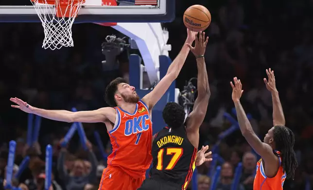 Oklahoma City Thunder center Chet Holmgren (7) attempts to block a shot by Atlanta Hawks forward Onyeka Okongwu (17) as Thunder guard Cason Wallace, right, watches during the second half of an NBA basketball game Monday, Dec. 29, 2025, in Oklahoma City. (AP Photo/Nate Billings)