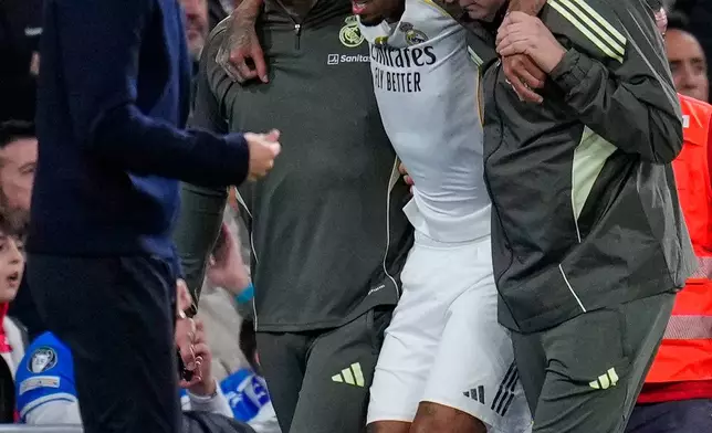 Real Madrid's Eder Militao is assisted from the pitch after getting an injury during the Spanish La Liga soccer match between Real Madrid and Celta Vigo in Madrid, Spain, Sunday, Dec. 7, 2025. (AP Photo/Manu Fernandez)