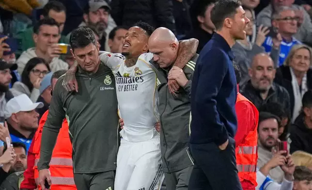 Real Madrid's Eder Militao is assisted from the pitch after getting an injury during the Spanish La Liga soccer match between Real Madrid and Celta Vigo in Madrid, Spain, Sunday, Dec. 7, 2025. (AP Photo/Manu Fernandez)