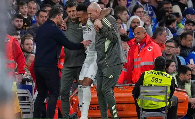 Real Madrid's head coach Xabi Alonso checks on Eder Militao who is assisted from the pitch after getting an injury during the Spanish La Liga soccer match between Real Madrid and Celta Vigo in Madrid, Spain, Sunday, Dec. 7, 2025. (AP Photo/Manu Fernandez)