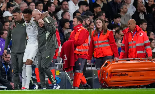 Real Madrid's Eder Militao is assisted from the pitch after getting an injury during the Spanish La Liga soccer match between Real Madrid and Celta Vigo in Madrid, Spain, Sunday, Dec. 7, 2025. (AP Photo/Manu Fernandez)