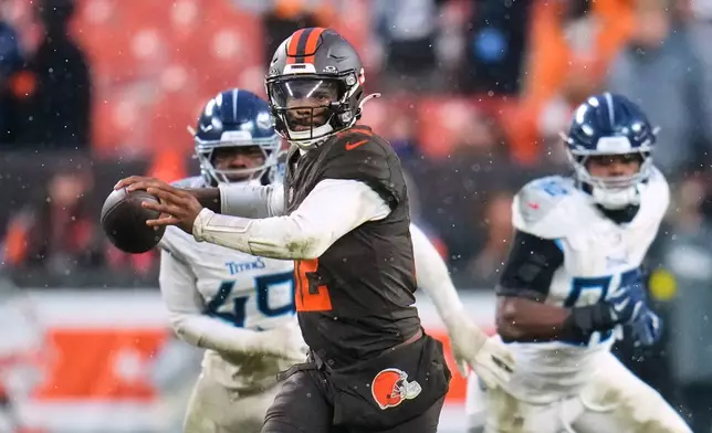 Cleveland Browns quarterback Shedeur Sanders (12) throws a pass under pressure from Tennessee Titans defenders in the second half of an NFL football game in Cleveland, Sunday, Dec. 7, 2025. (AP Photo/Sue Ogrocki)