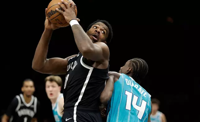 Brooklyn Nets center Day'Ron Sharpe, left, drives past Charlotte Hornets forward Moussa Diabate (14) during the first half of an NBA basketball game Monday, Dec. 1, 2025, in New York. (AP Photo/Adam Hunger)