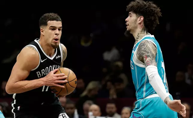 Brooklyn Nets forward Michael Porter Jr., left, drives past Charlotte Hornets guard LaMelo Ball, right, during the first half of an NBA basketball game Monday, Dec. 1, 2025, in New York. (AP Photo/Adam Hunger)
