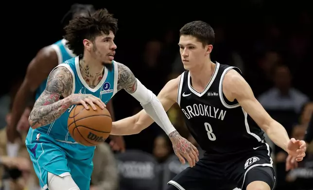 Charlotte Hornets guard LaMelo Ball, left, drives past Brooklyn Nets guard Egor Demin (8) during the first half of an NBA basketball game, Monday, Dec. 1, 2025, in New York. (AP Photo/Adam Hunger)