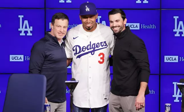 Edwin Díaz, middle, poses for photos next to General Manager Brandon Gomes, right, and President of Baseball Operations Andrew Friedman during his introduction as a new member of the Los Angeles Dodgers baseball team Friday, Dec. 12, 2025, in Los Angeles. (AP Photo/Ethan Swope)
