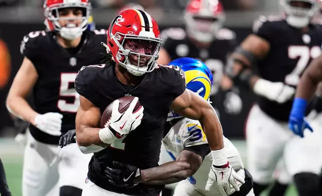 Atlanta Falcons running back Bijan Robinson (7) carries for a long gain against Los Angeles Rams safety Kam Curl (3) in the second half of an NFL football game, Monday, Dec. 29, 2025, in Atlanta. (AP Photo/Mike Stewart)