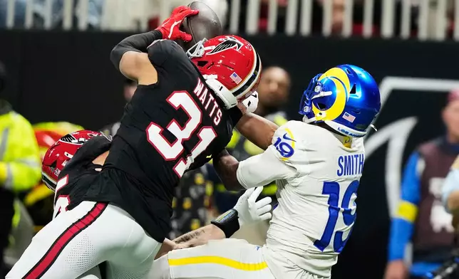 Atlanta Falcons safety Xavier Watts (31) intercepts a pass intended for Los Angeles Rams wide receiver Xavier Smith (19) in the first half of an NFL football game, Monday, Dec. 29, 2025, in Atlanta. (AP Photo/Brynn Anderson)