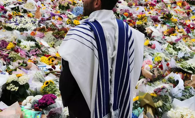 FILE - Rabbi Yossi Friedman speaks to people gathering at a flower memorial by the Bondi Pavilion at Bondi Beach on Tuesday, Dec. 16, 2025, following Sunday's shooting in Sydney, Australia. (AP Photo/Mark Baker, File)