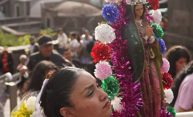 FILE - A pilgrim carries a statue of the Virgin of Guadalupe at the Basilica of Our Lady of Guadalupe in Mexico City, on her feast day, Friday, Dec. 12, 2025. (AP Photo/Jon Orbach, File)