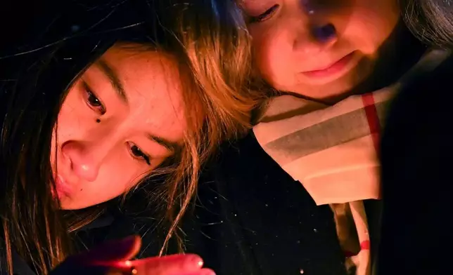 FILE - People hold candles during a vigil, Sunday, Dec. 14, 2025, in Providence, R.I., for those injured or killed in the Saturday shooting on the campus of Brown University. (AP Photo/Steven Senne, FIle)