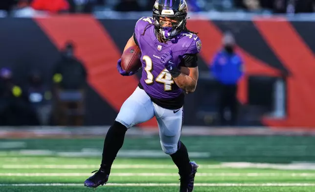 Baltimore Ravens running back Keaton Mitchell (34) runs the ball during the first half of an NFL football game against the Cincinnati Bengals, Sunday, Dec. 14, 2025, in Cincinnati. (AP Photo/Jeff Dean)