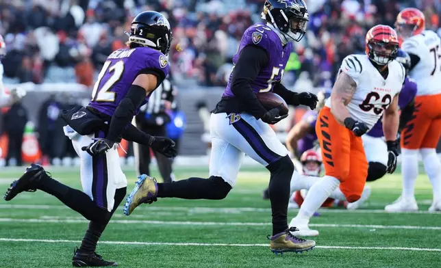 Baltimore Ravens linebacker Kyle van Noy (53), with safety Alohi Gilman (12) running next to him, returns an interception during the second half of an NFL football game against the Cincinnati Bengals, Sunday, Dec. 14, 2025, in Cincinnati. (AP Photo/Jeff Dean)