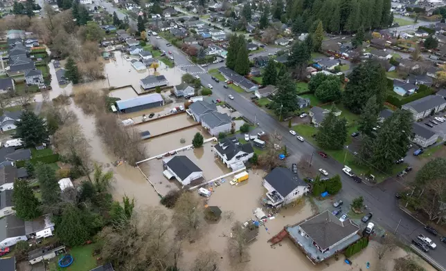 Portions of a neighborhood are flooded on Friday, Dec. 12, 2025, in Burlington, Wash. (AP Photo/Stephen Brashear)