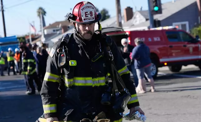 A firefighter walks near the scene of a gas explosion Thursday, Dec. 11, 2025, in Hayward, Calif. (AP Photo/Godofredo A. Vásquez)