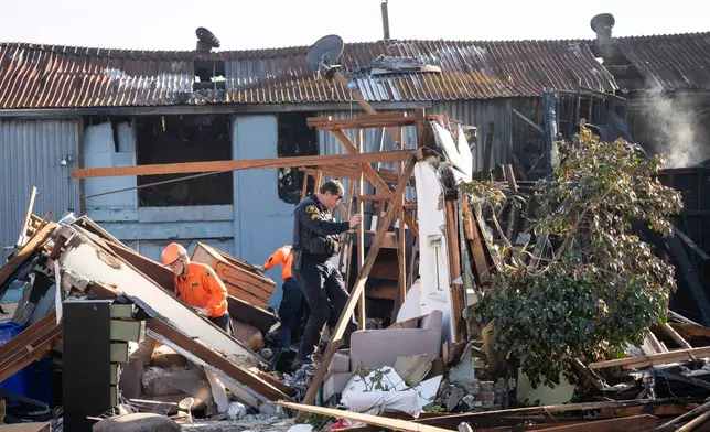 Alameda County Police Officers and Search and Rescue access the aftermath at the site of the explosion on the 800 block of East Lewelling Boulevard, Thursday, Dec. 11, 2025, in Hayward, Calif. (AP Photo/Minh Connors)