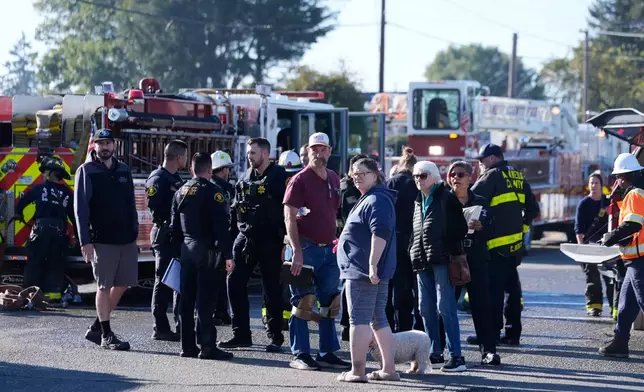 Onlookers and emergency responders gather at the scene of a gas explosion Thursday, Dec. 11, 2025, in Hayward, Calif. (AP Photo/Godofredo A. Vásquez)